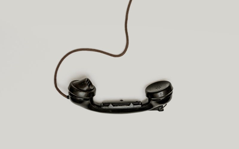 A photgraph of a black retro telephone on a grey background
