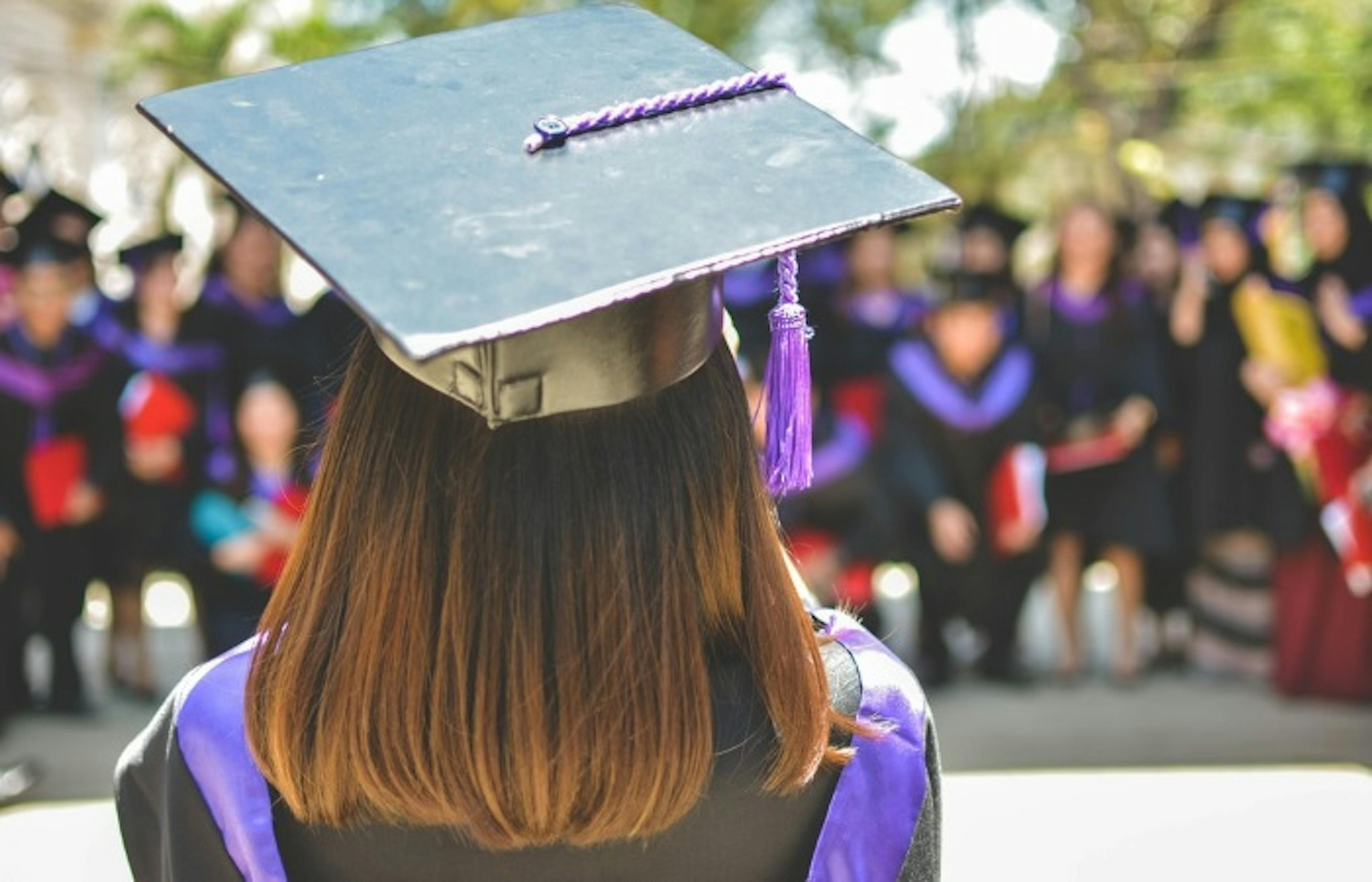 The back of the head of a woman waiting at a graduation ceremony