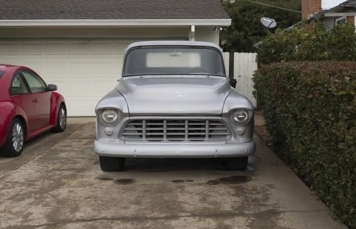 Silver vintage car parked in a driveway
