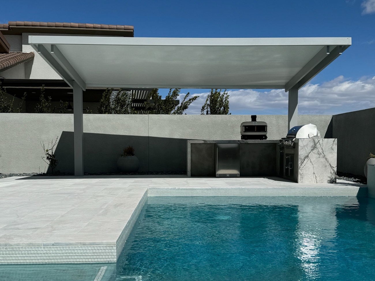 Toldo de lujo gris y blanco 4K que cubre la cocina exterior junto a la piscina en Las Vegas, Nevada.