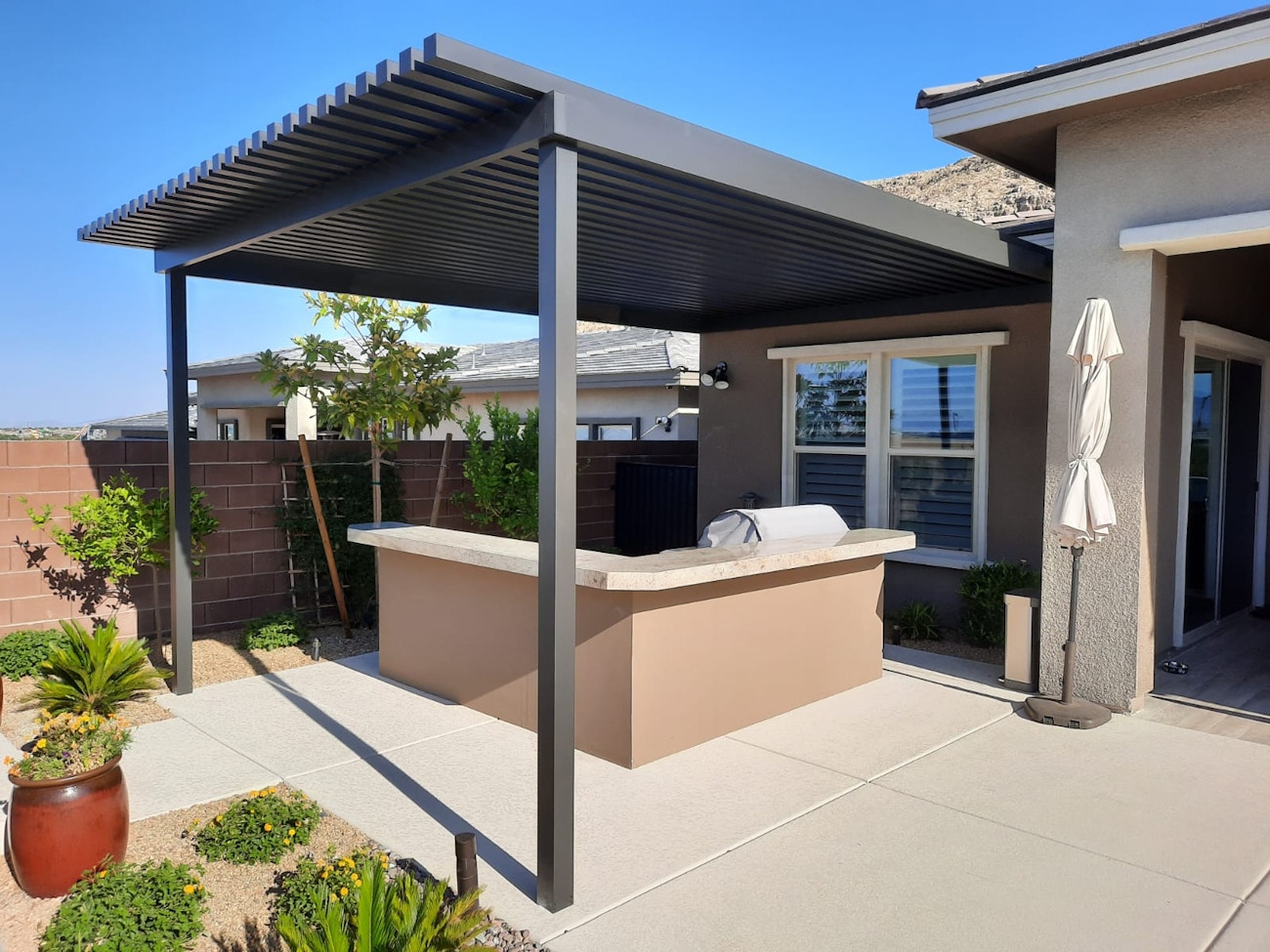 Attached 4K aluminum patio cover protecting outdoor kitchen for Las Vegas, Nevada home