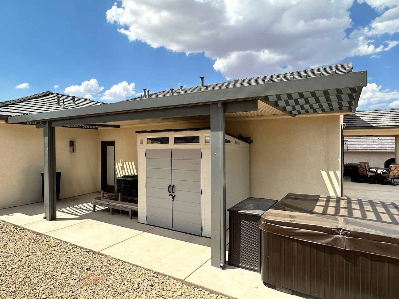 Gray aluminum solid top patio cover providing shade and protection for hot tub in Gilbert, Arizona