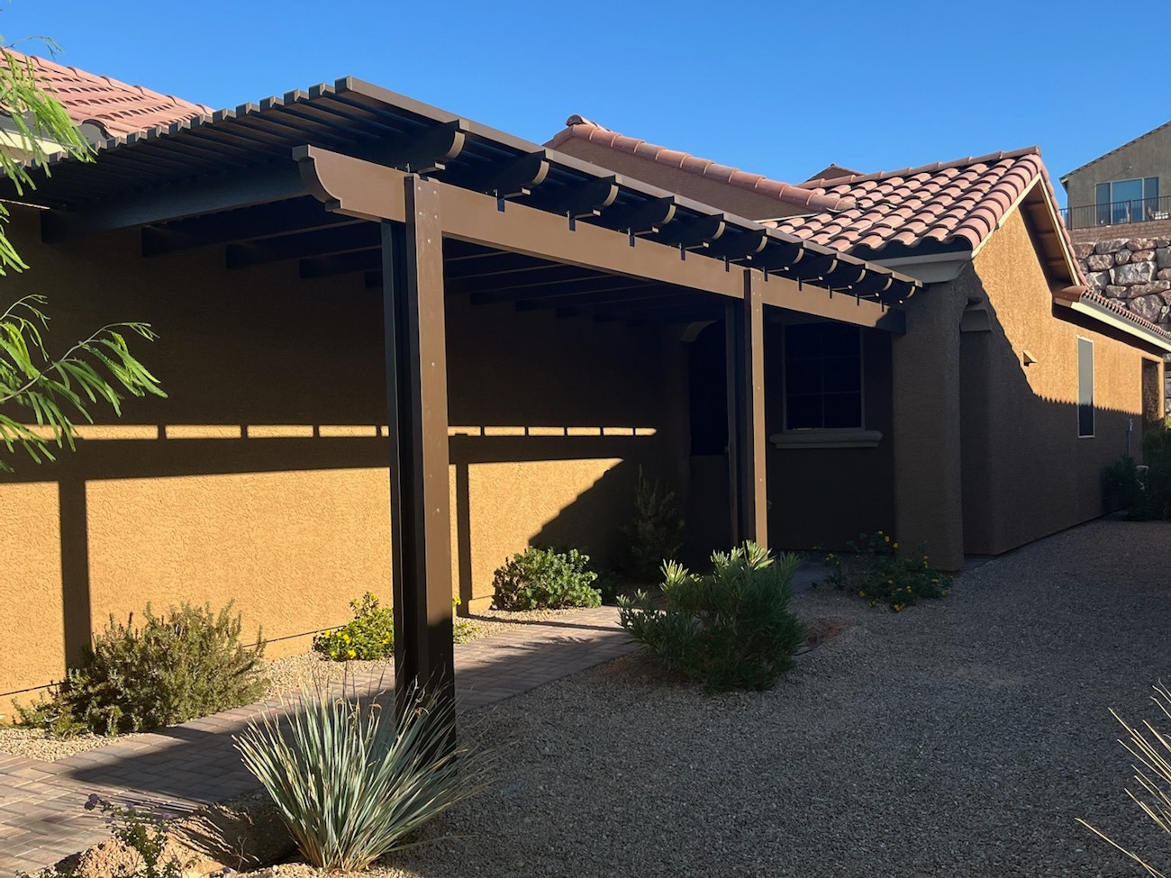 Impresionante cubierta de celosía de aluminio marrón que proporciona sombra a la pasarela de una vivienda en Phoenix, Arizona.