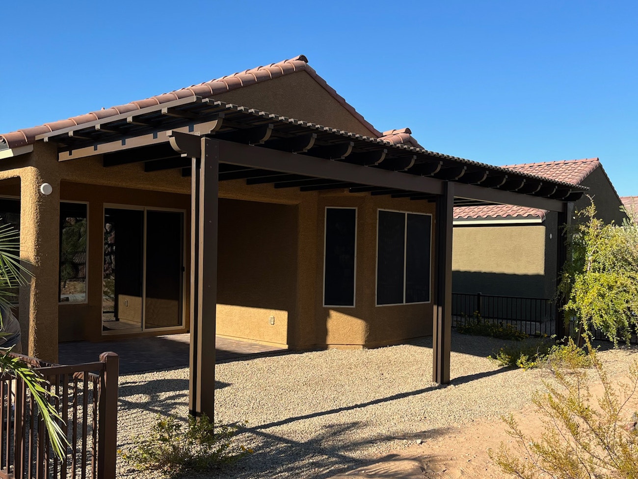 Cubierta para patio de estilo celosía marrón con vigas en voladizo instalada en Phoenix, Arizona.
