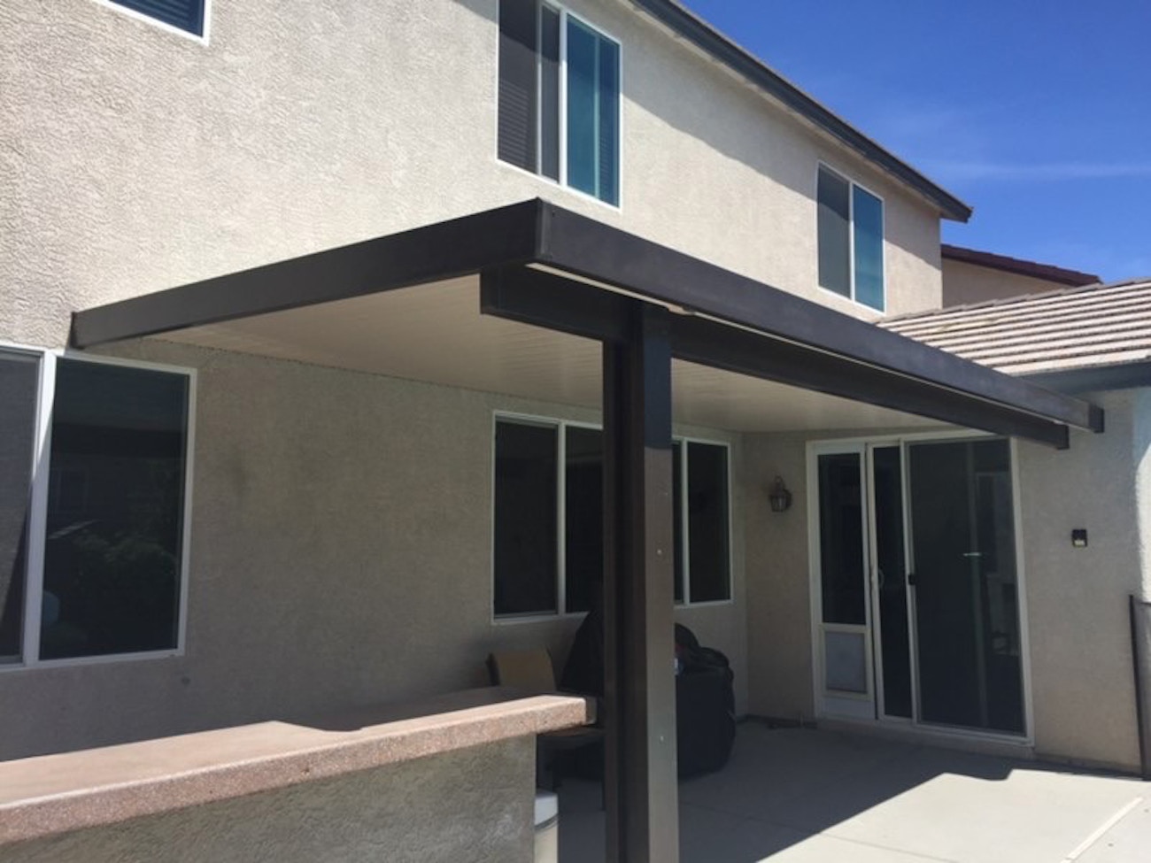 Toldo de aluminio con techo sólido, marco marrón de dos tonos y techo blanco instalado en St. George, Utah.