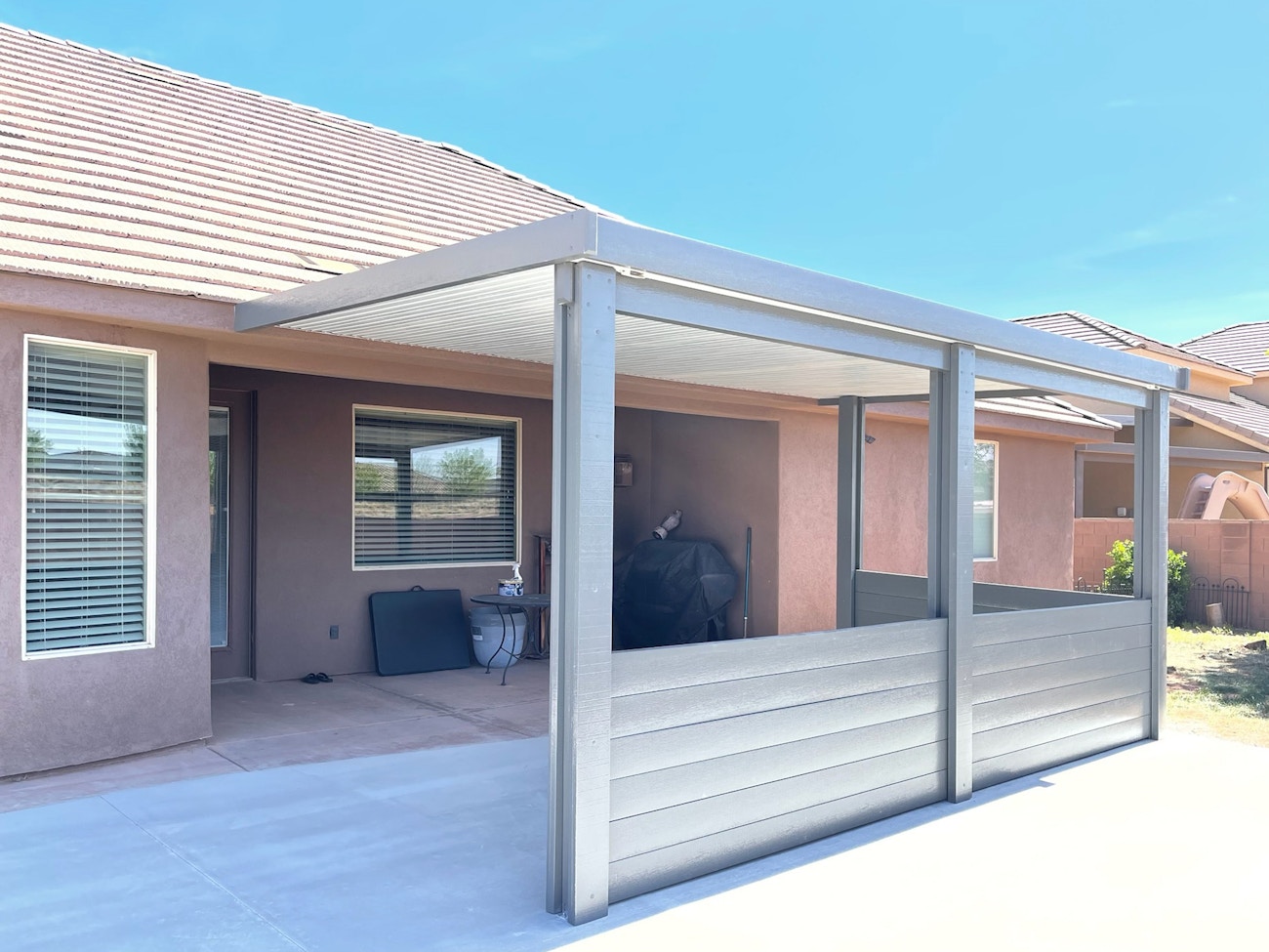 Aluminum patio cover with a solid top featuring a privacy wall at the bottom installed in Washington, UT
