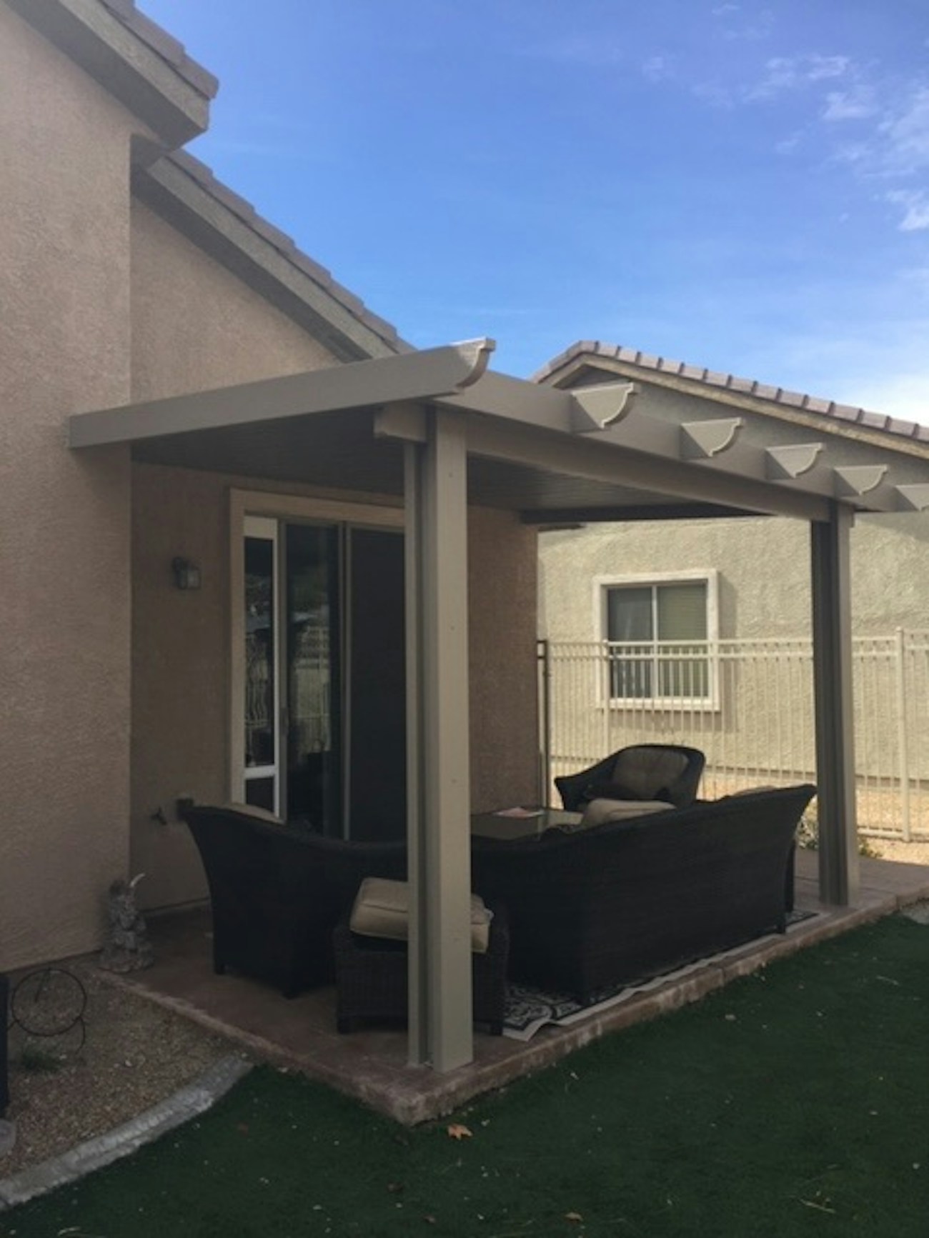 Beige solid top aluminum patio cover with rafter tails installed in Washington, Utah