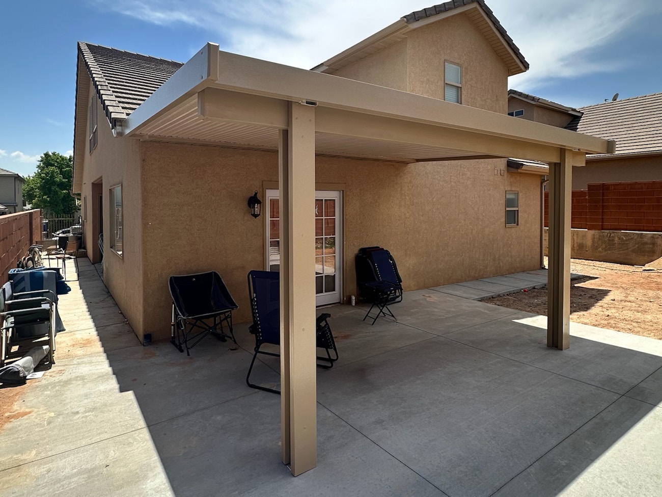 Simple tan patio cover with aluminum material providing full shade in St. George, Utah