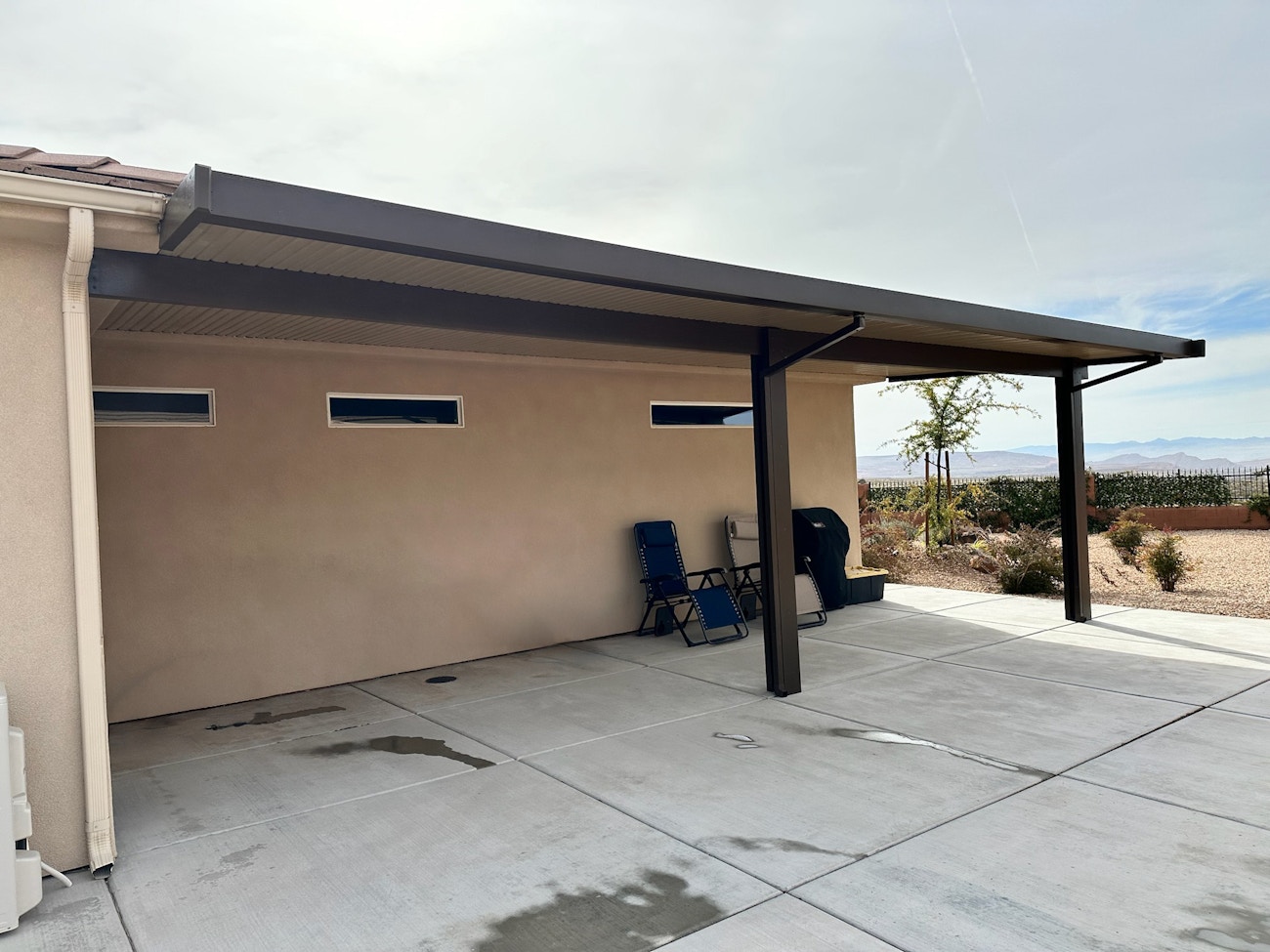 Dark brown aluminum patio cover in side yard for Saint George, UT residence.
