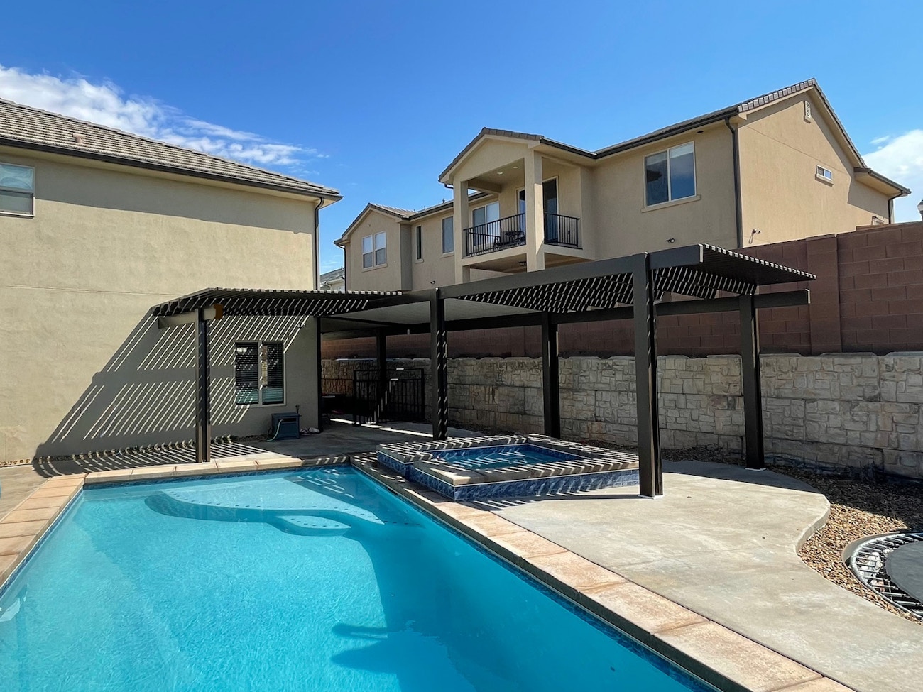 Cubierta combinada de celosía en color marrón que proporciona sombra a la tina de hidromasaje en el patio trasero de Saint George, Utah.