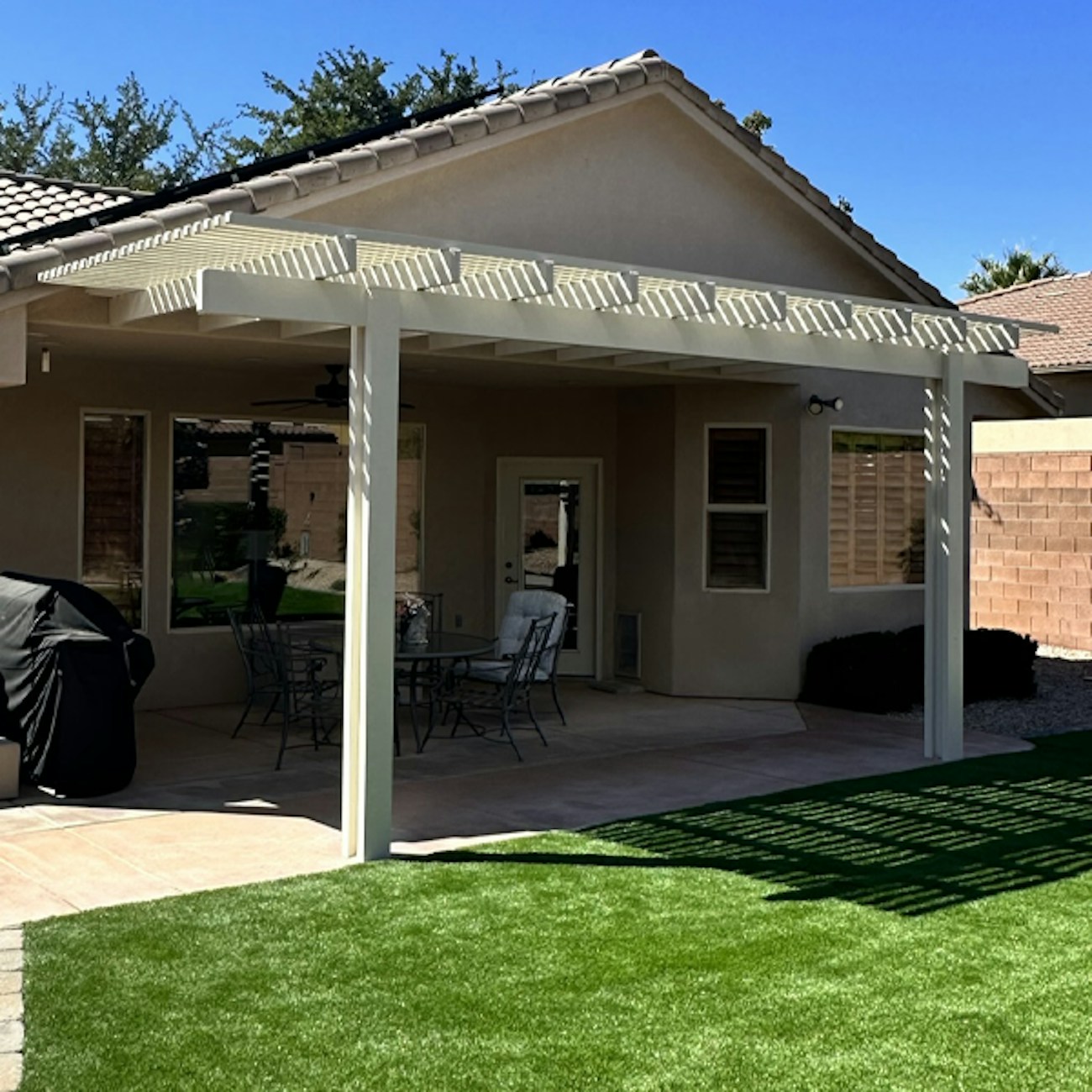 Toldo de celosía blanca que proporciona sombra filtrada instalado en Washington, Utah.