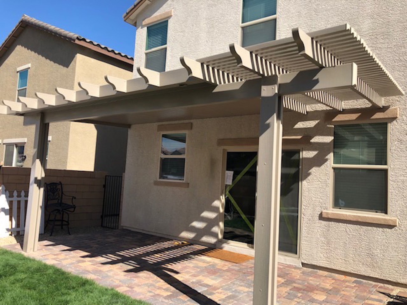 Tan lattice-style patio covering back porch for Washington, Utah home