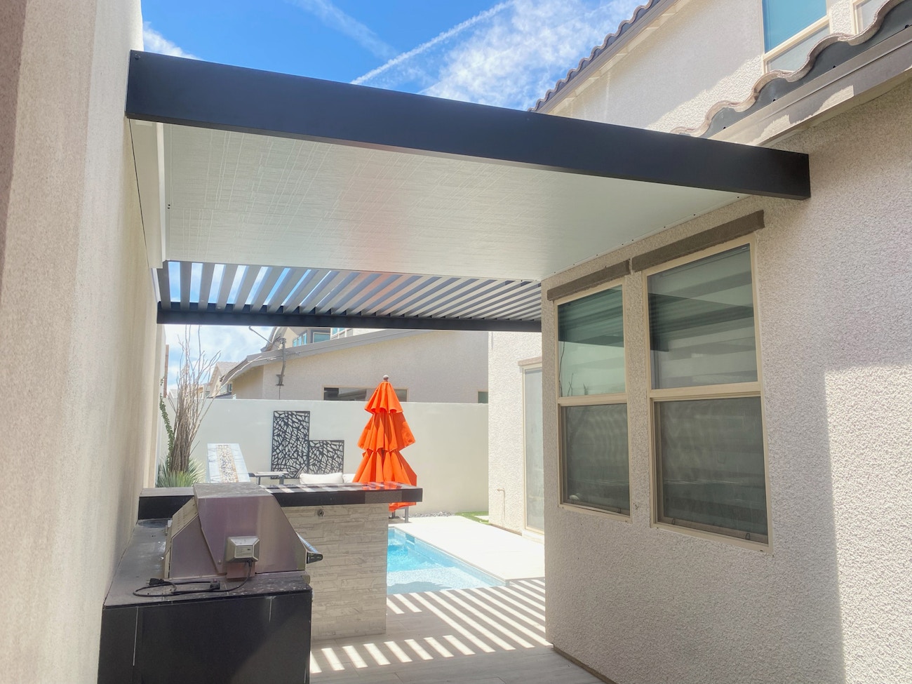 Premium 4K luxury aluminum cover in black with white ceiling covering outdoor kitchen in Saint George, UT