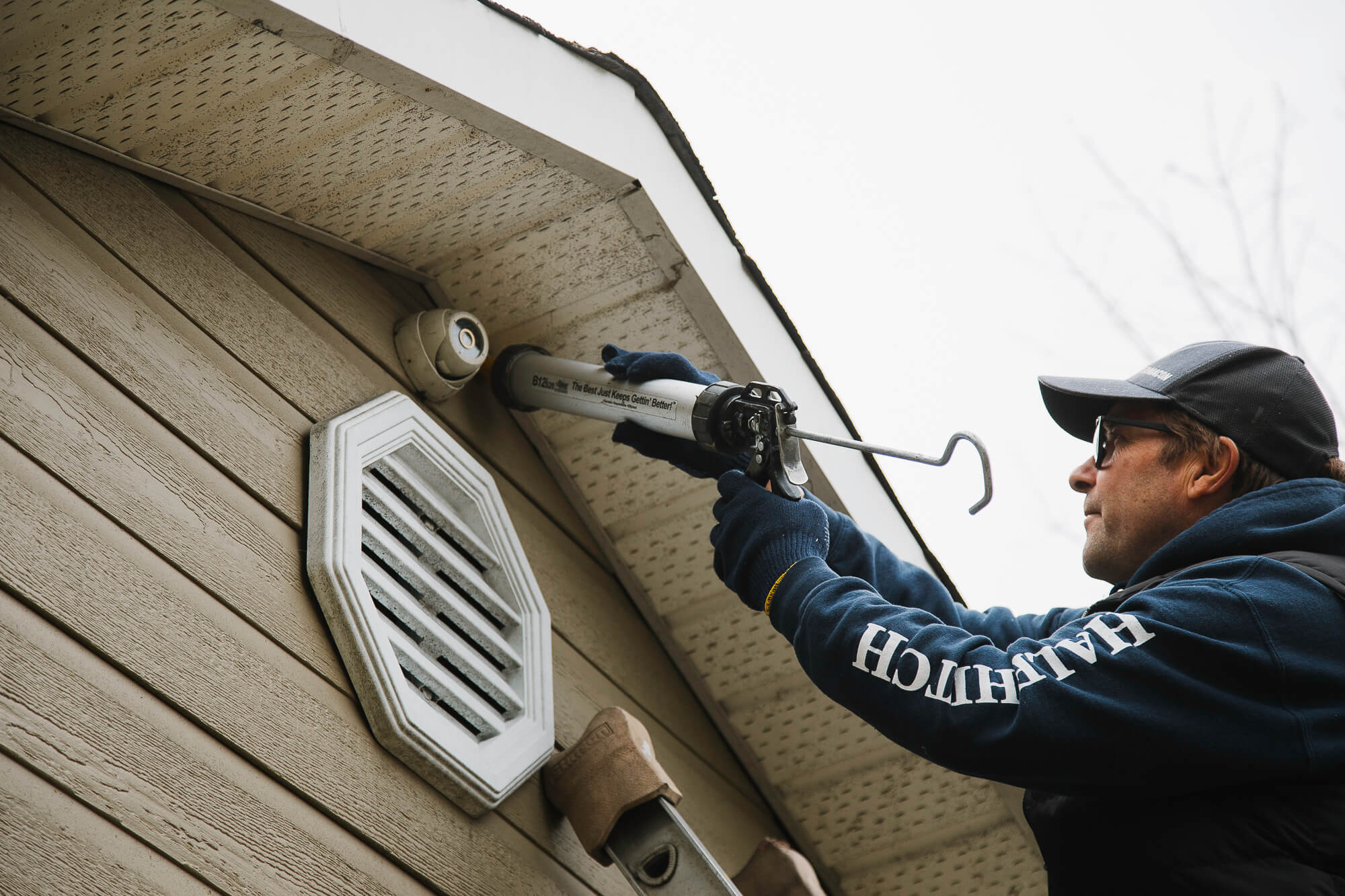 Un homme calfeutrant une maison.