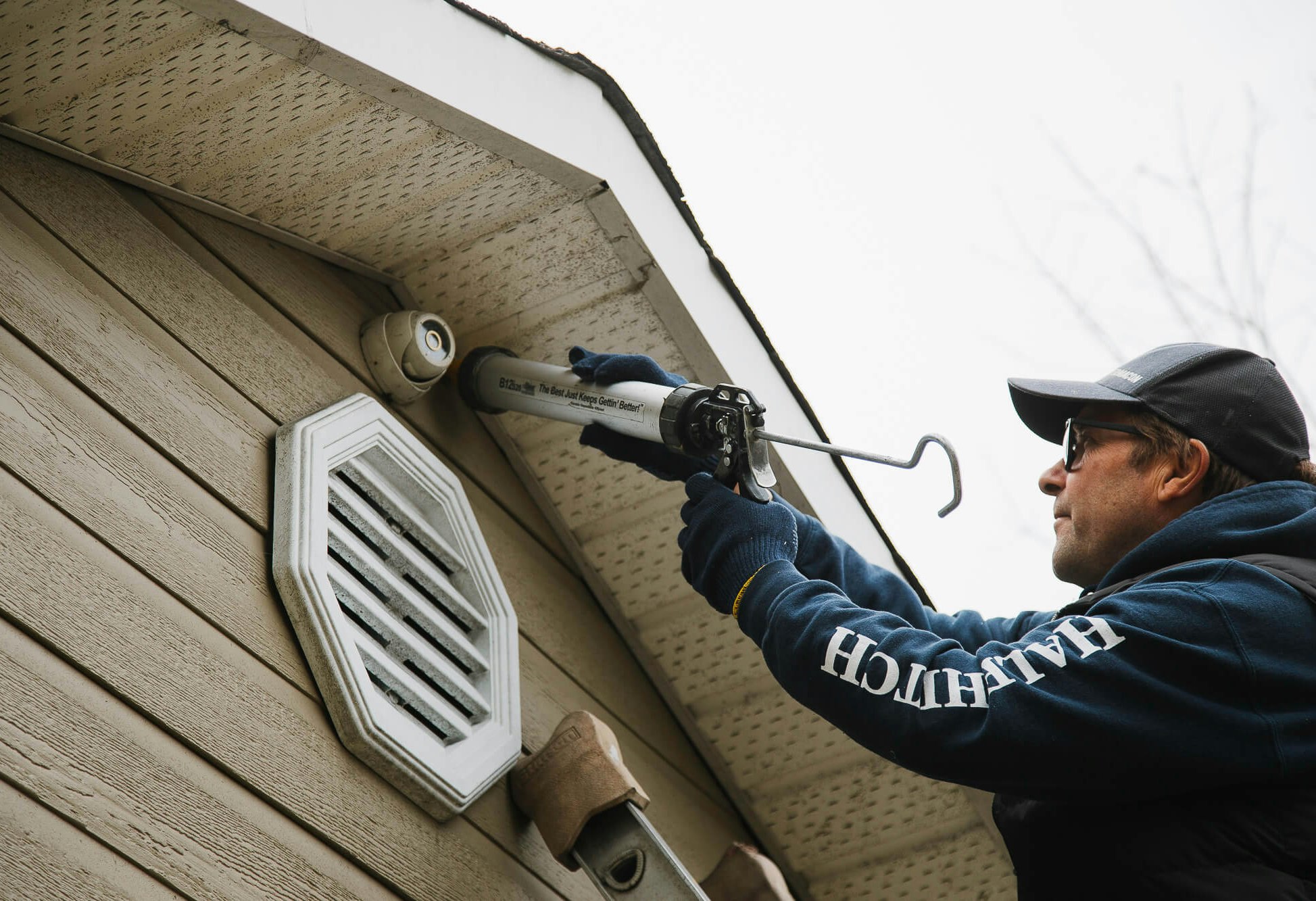 Un homme calfeutrant une maison.