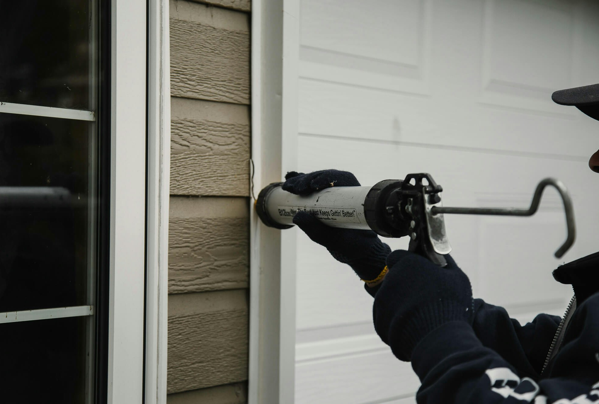 Un homme calfeutrant une maison.