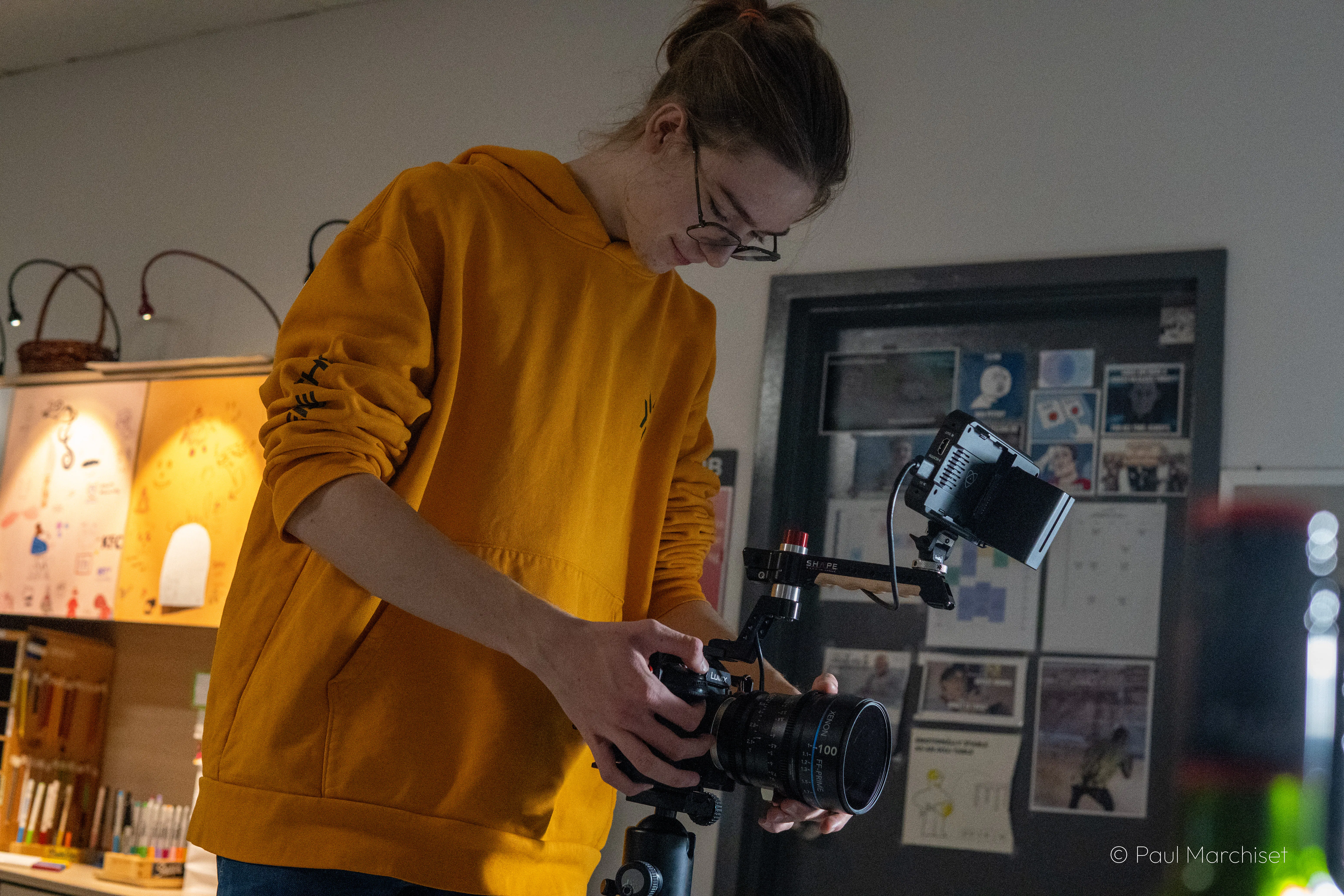 Picture of Paul Marchiset holding a camera with a yellow sweatshirt - Picture by Alexis Bernard