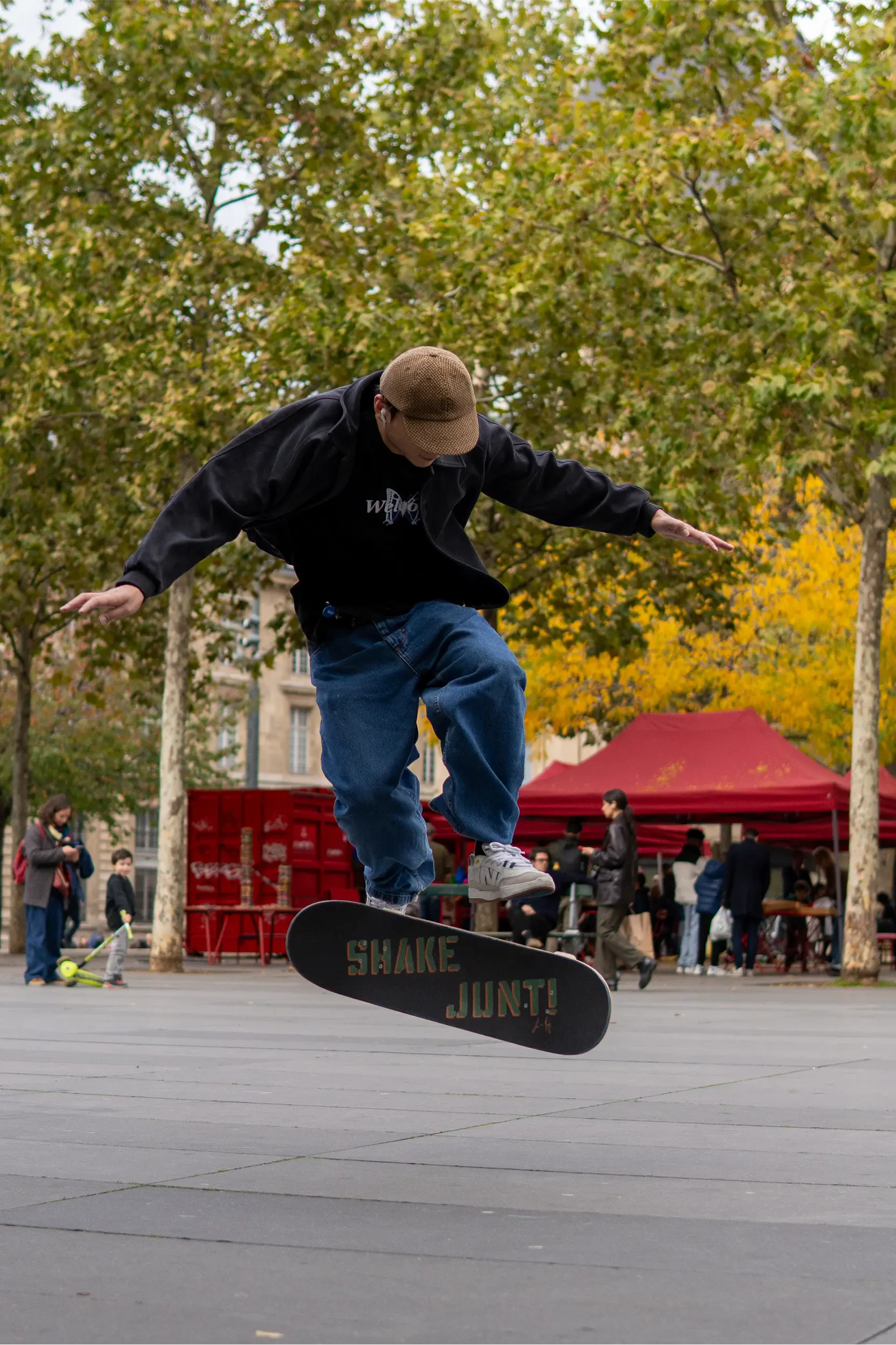 skater flip with his board where "shake junt" is written