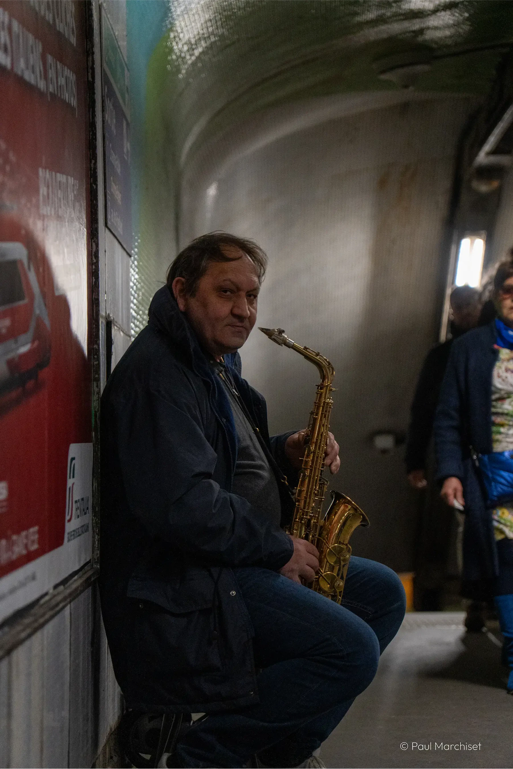 guy playing the saxophone inside the subway