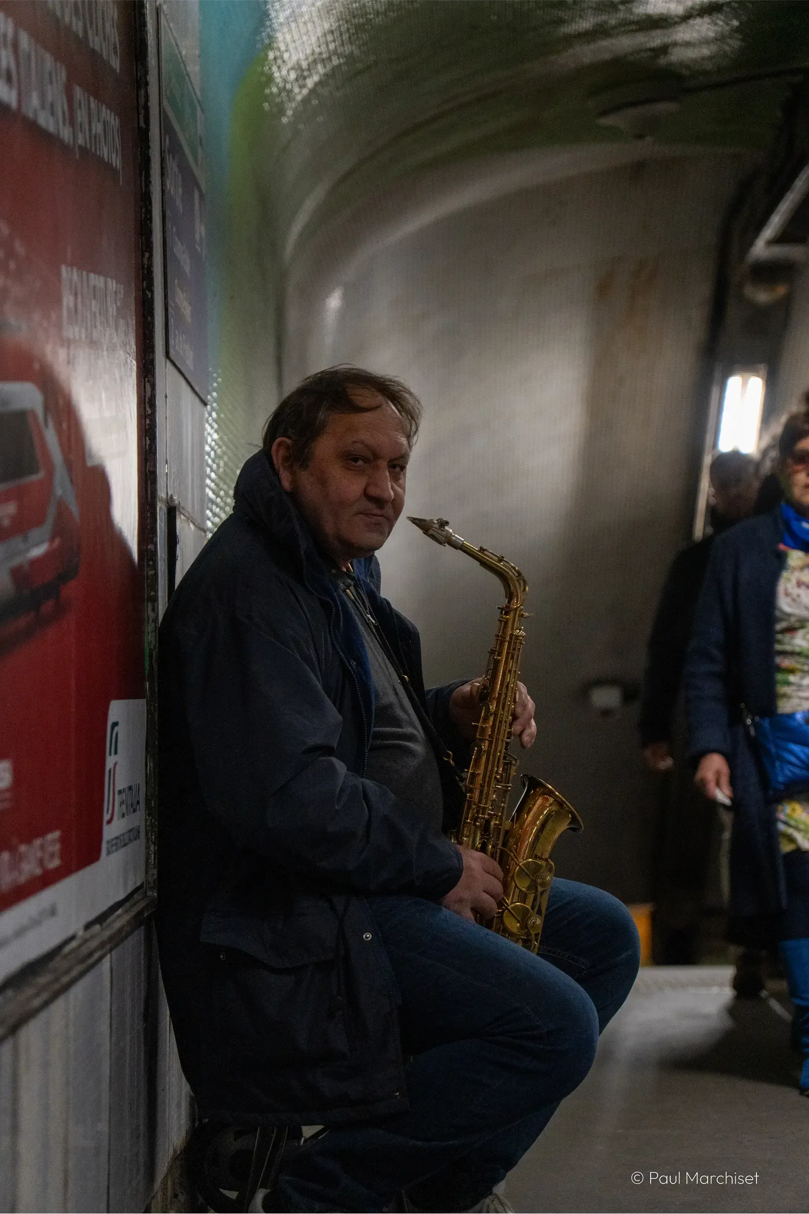 guy playing the saxophone inside the subway