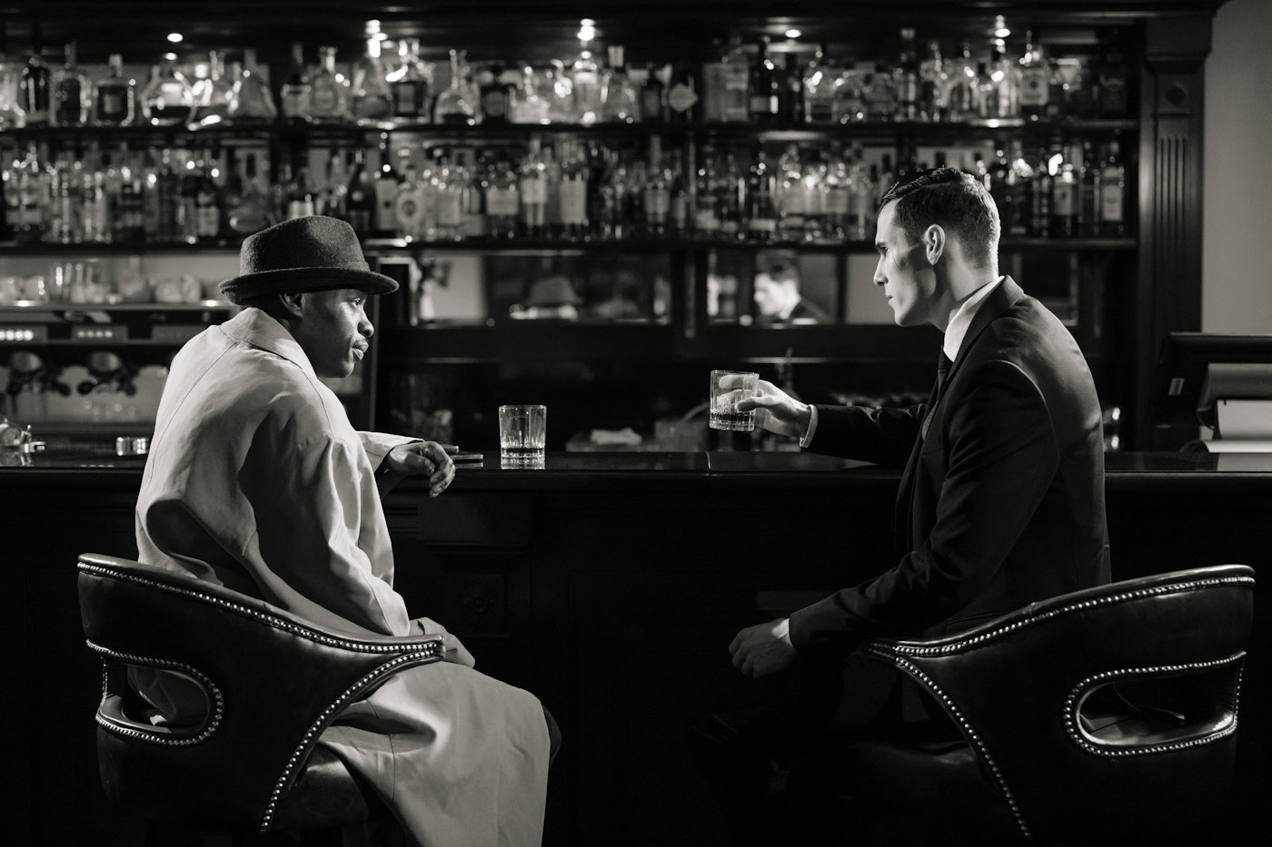 black and white picture of two men talking at a bar