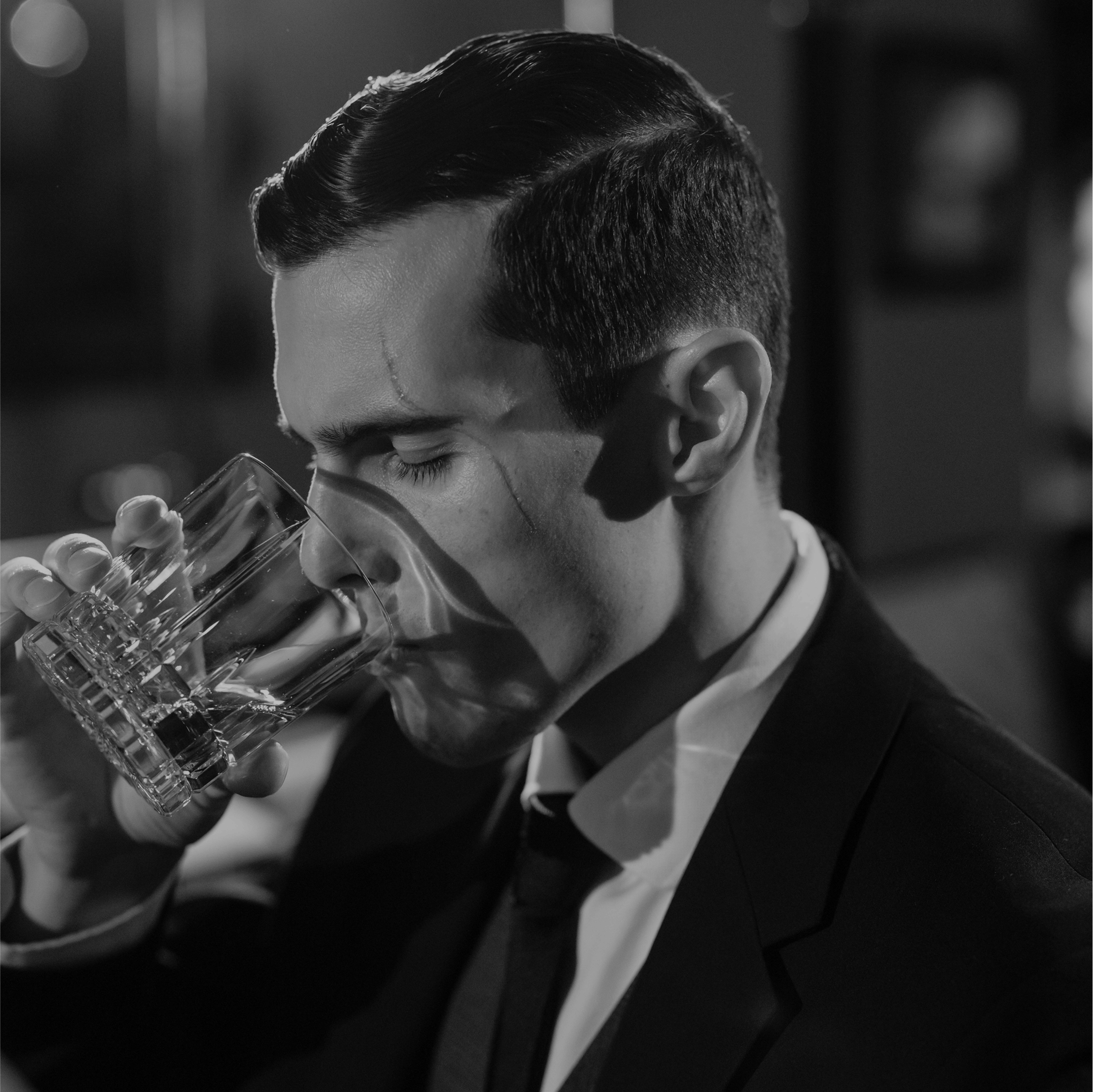 man drinking a glass of alcohol