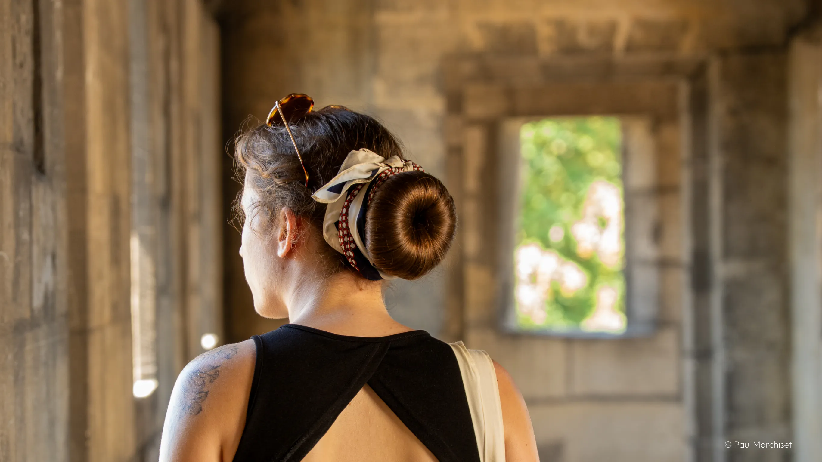 a young woman from the back inside an old fortress path