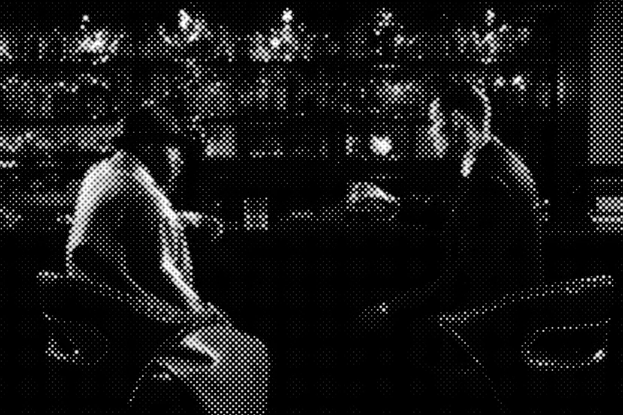 black and white picture of two men talking at a bar