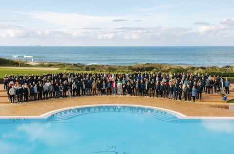 Una foto di gruppo scattata in una piscina che ritrae centinaia di dipendenti di beqom.
