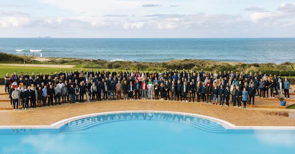 Una foto di gruppo scattata in una piscina che ritrae centinaia di dipendenti di beqom.