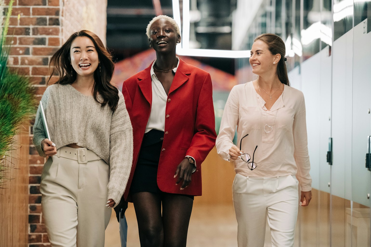 Three women at work walking and smiling