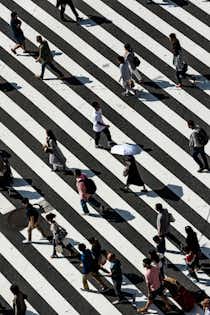 Ein Foto aus der Vogelperspektive von Menschen, die eine Straße überqueren.