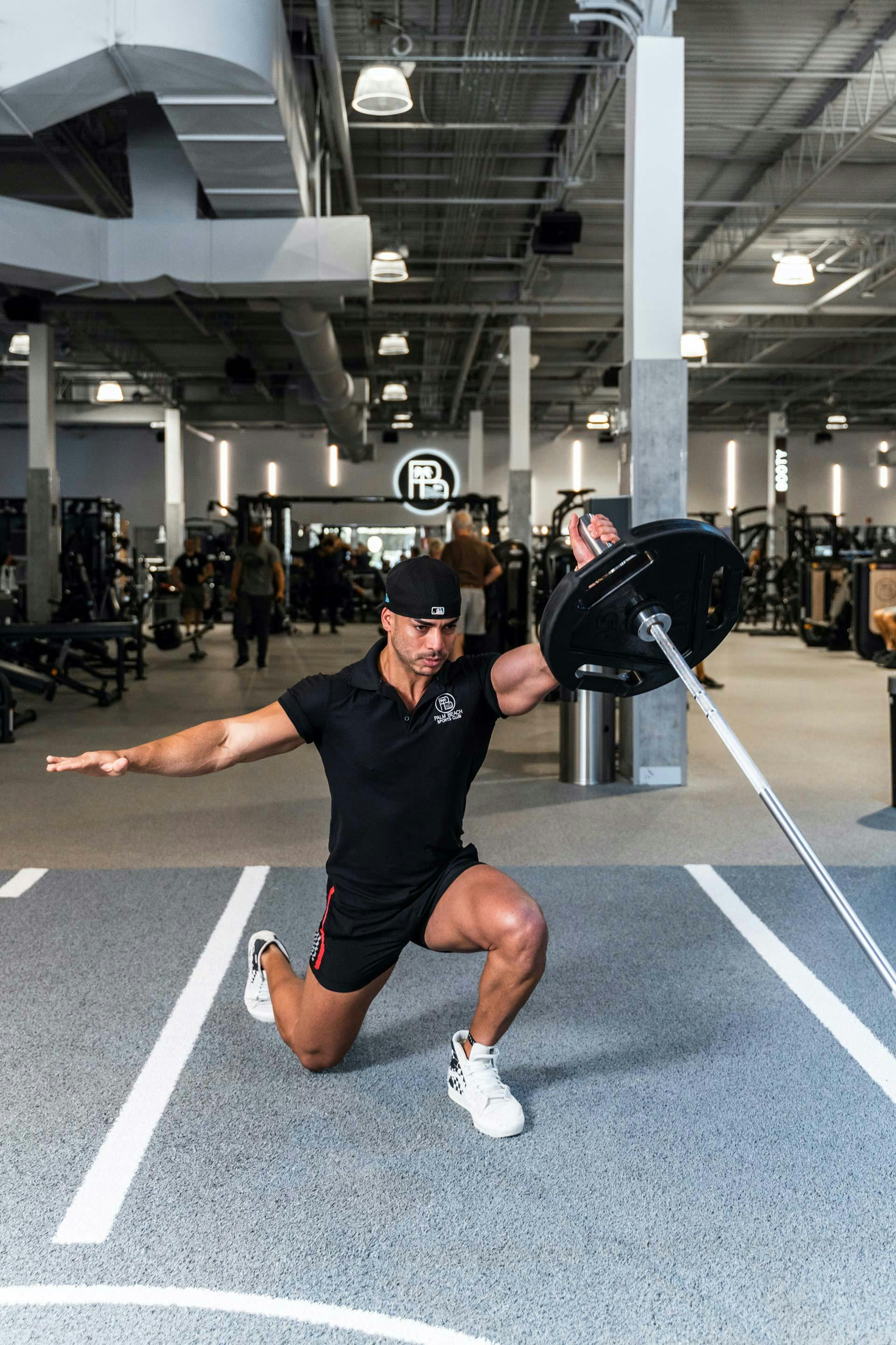 Trainer holding free weight on gym floor