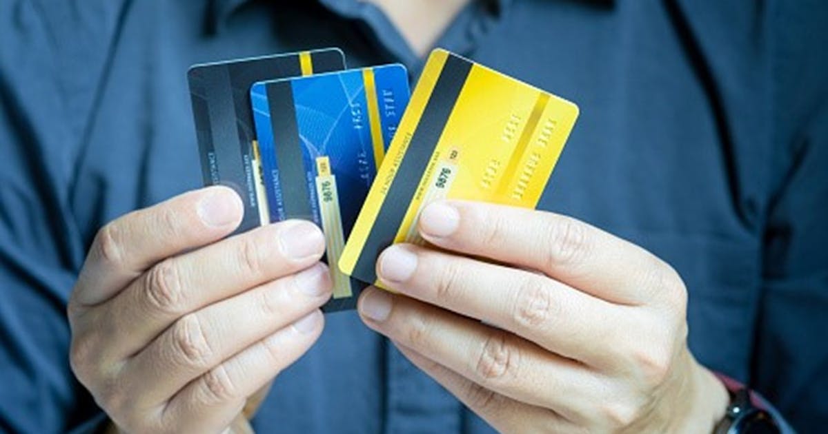 Hands holding three credit cards