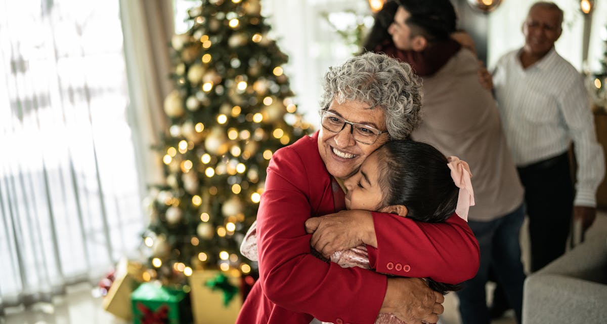 Grandmother hugging her granddaughter on christmas at home