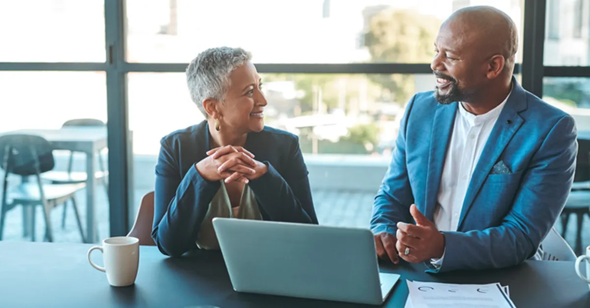 Mature woman and man having discussion laptop