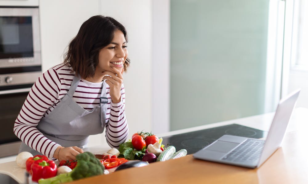 Young Woman on Laptop with Healthy Veggies