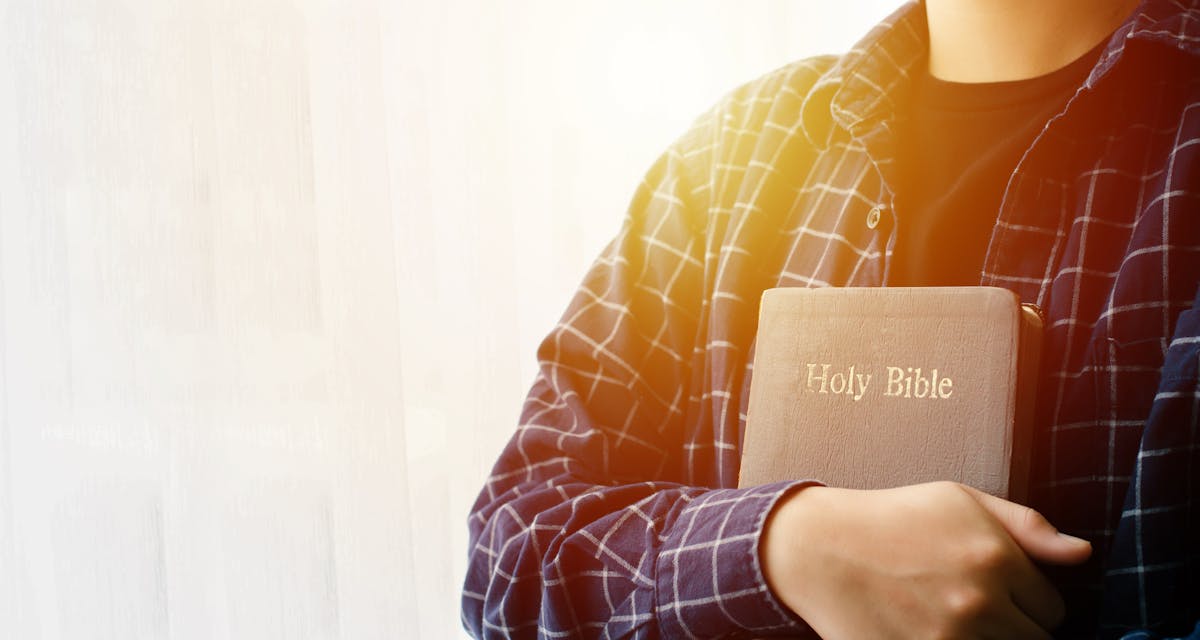 Young woman hugging bible