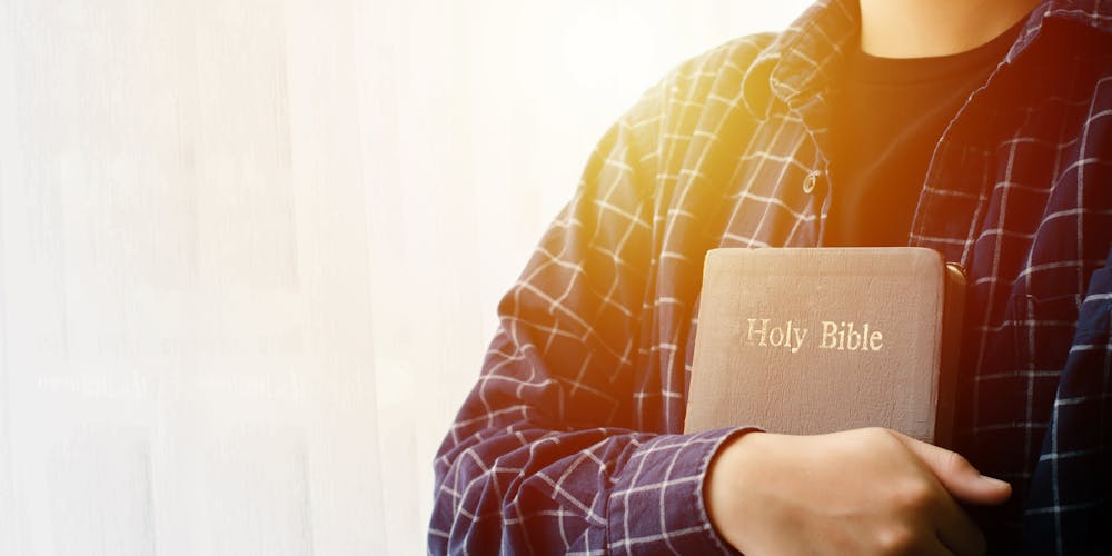 Young woman hugging bible