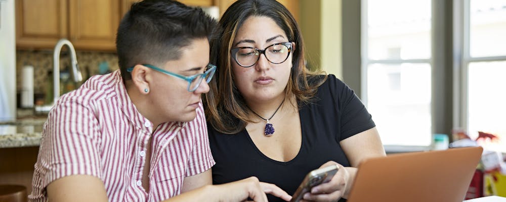 Young couple on laptop discussing finances