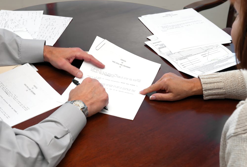 Couple pointing at financial documents on table