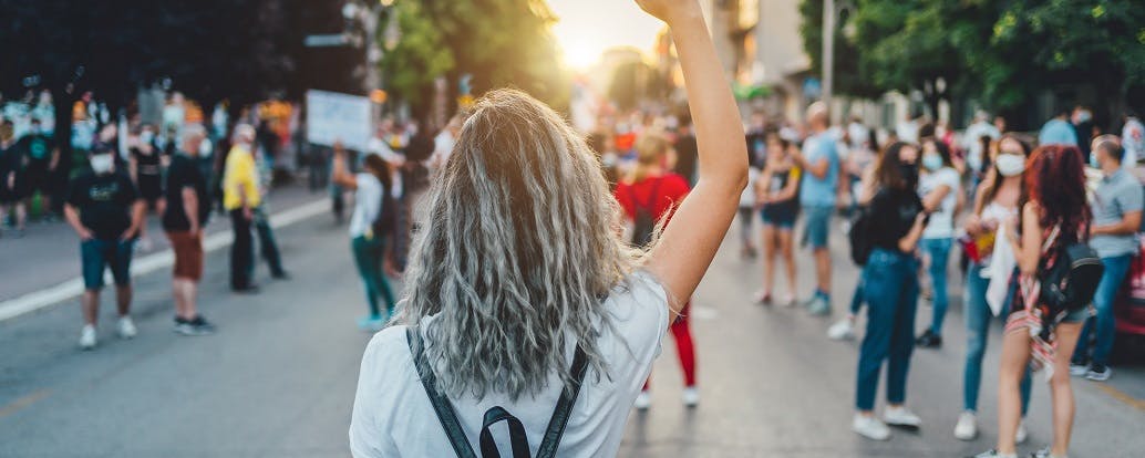 Young woman protester raising her fist up