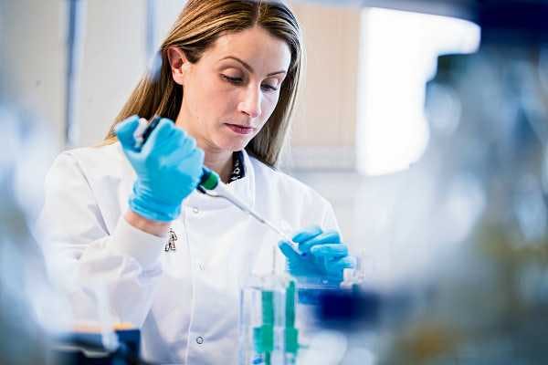 Photo of a researcher using a pipette and beaker.