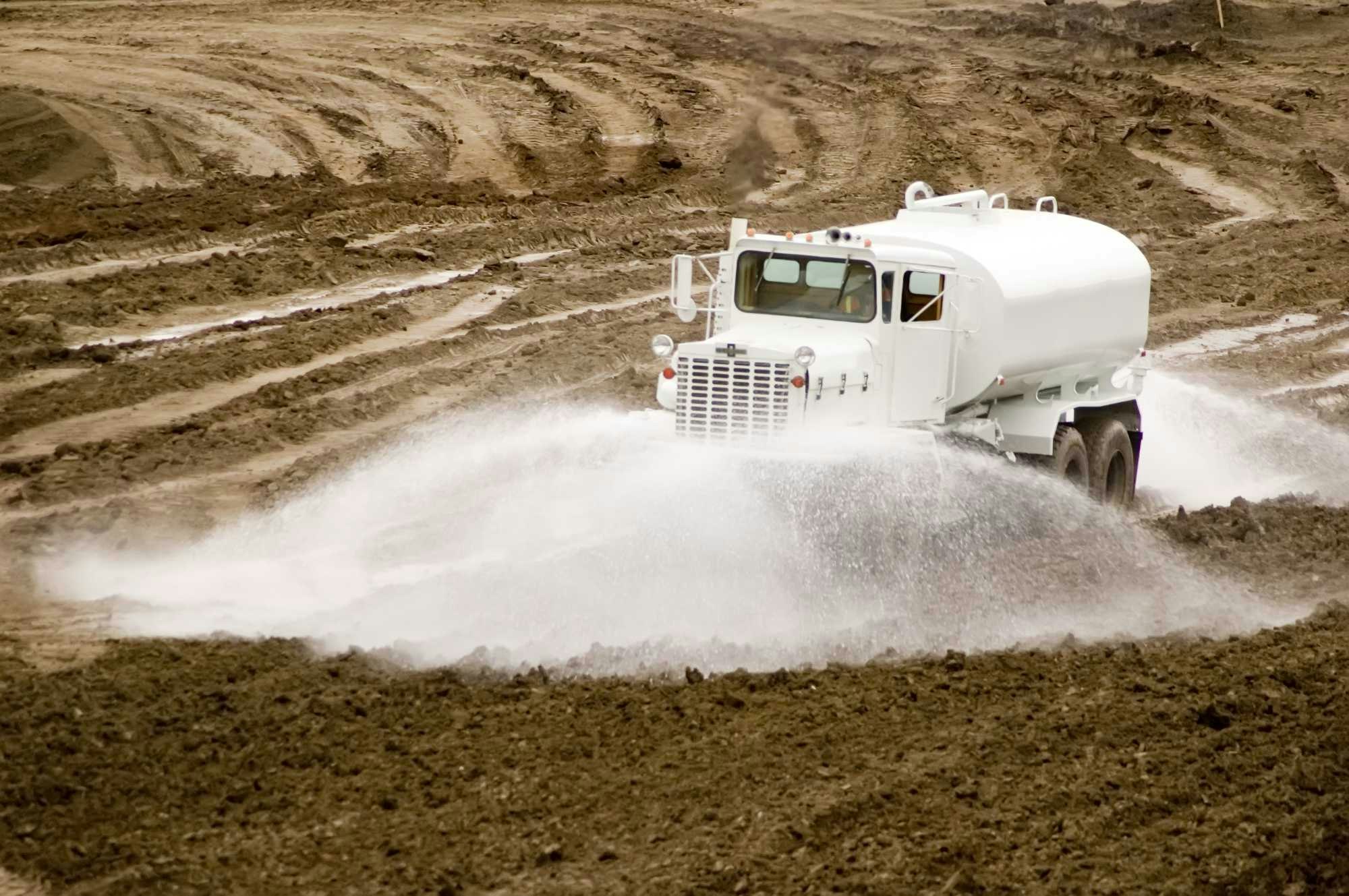 Peaceland water truck spraying down an oilfield lease