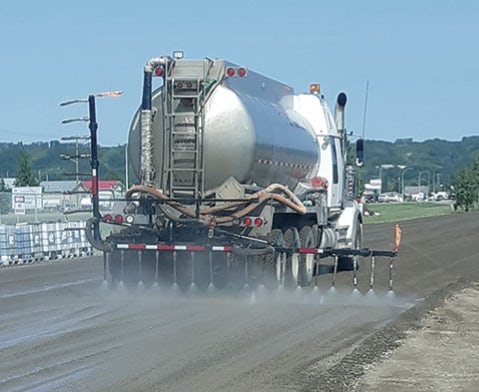 Peaceland water truck providing summer dust control on gravel road