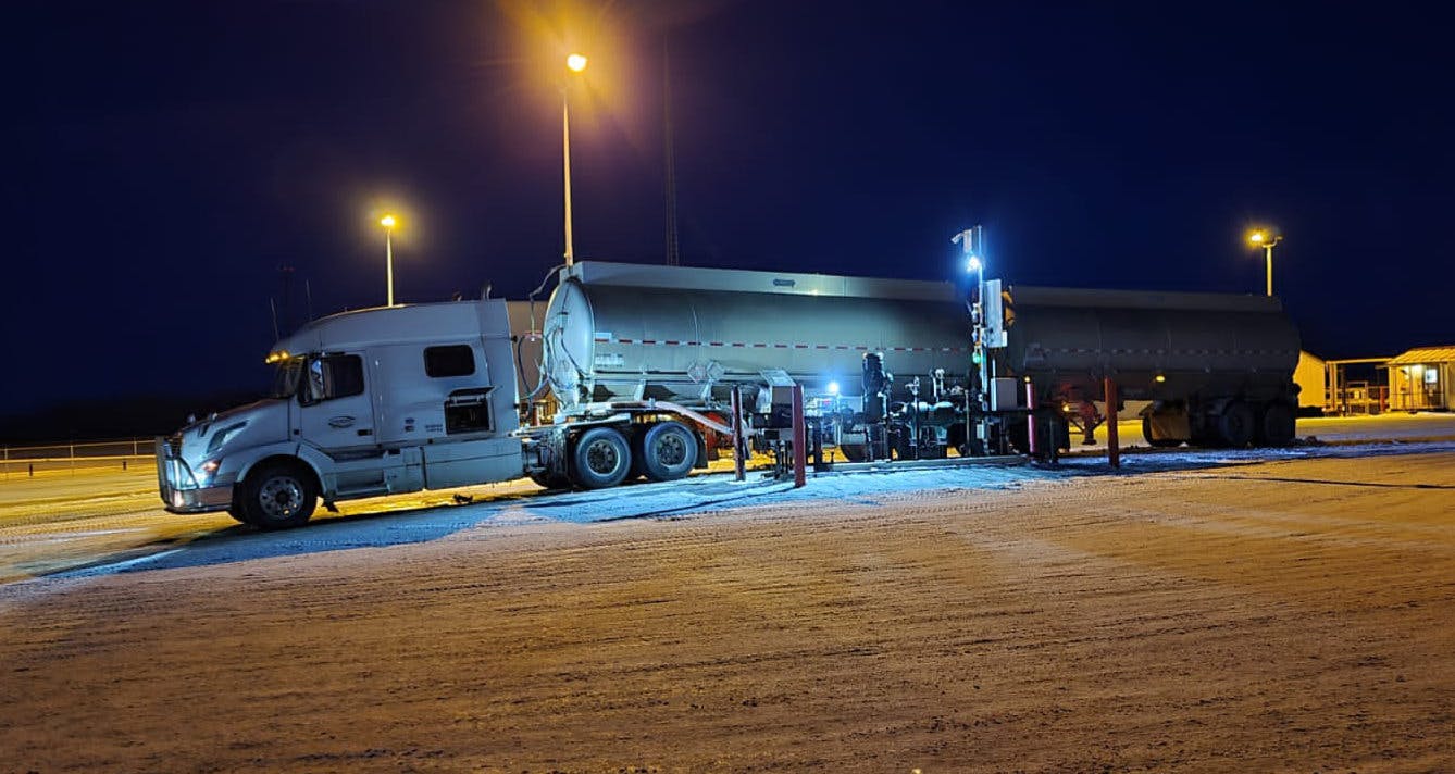 Peaceland tanker truck loading at an oil and gas facility at night