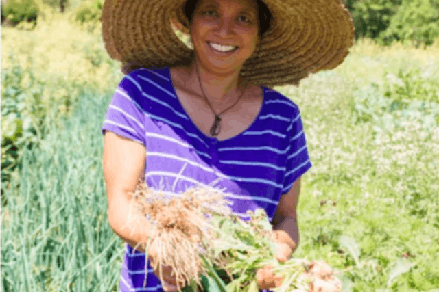 Jody of Jody's Farms holding a bushel of onions