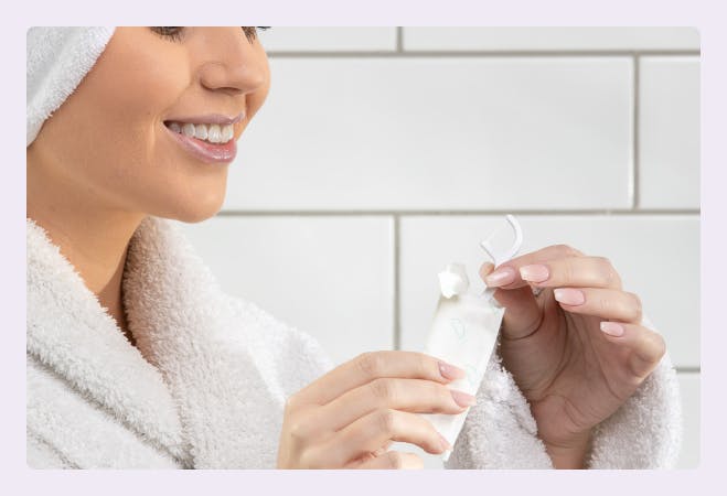 A girl in a bathroom, unwrapping a Pearlii Biofloss Easy Picks