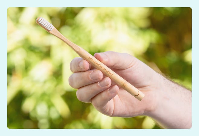 A hand holding up a Pearlii Mosobrush