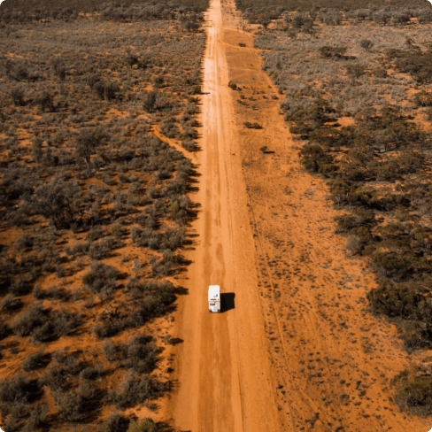 A truck drives across the outback